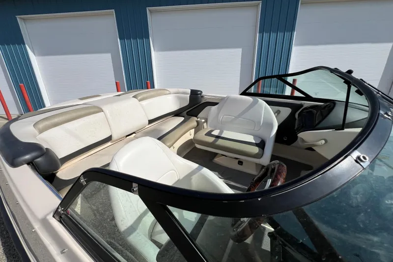 Slide: The Image of 2007 Bombardier Seadoo Utopia interior with white seating and steering wheel, parked near blue building. - 4