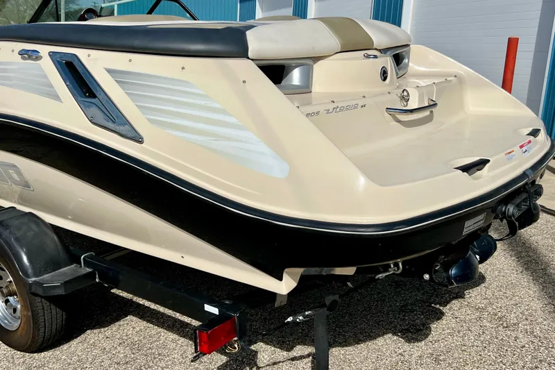 Slide: The Image of 2007 Bombardier Seadoo Utopia boat on trailer, rear view, beige and black design. - 8