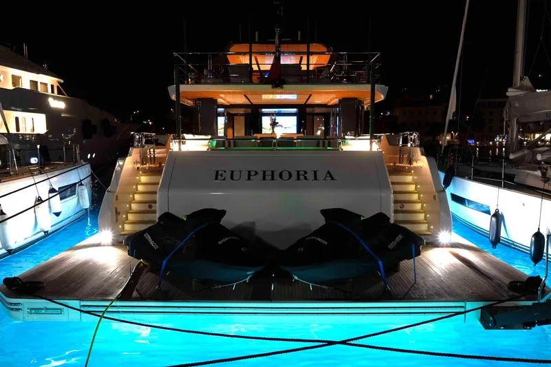 Slide: The Image of Luxurious 2025 Alpha 100 Squalo Co Ownership yacht "Euphoria" docked at night, illuminated in blue. - 13