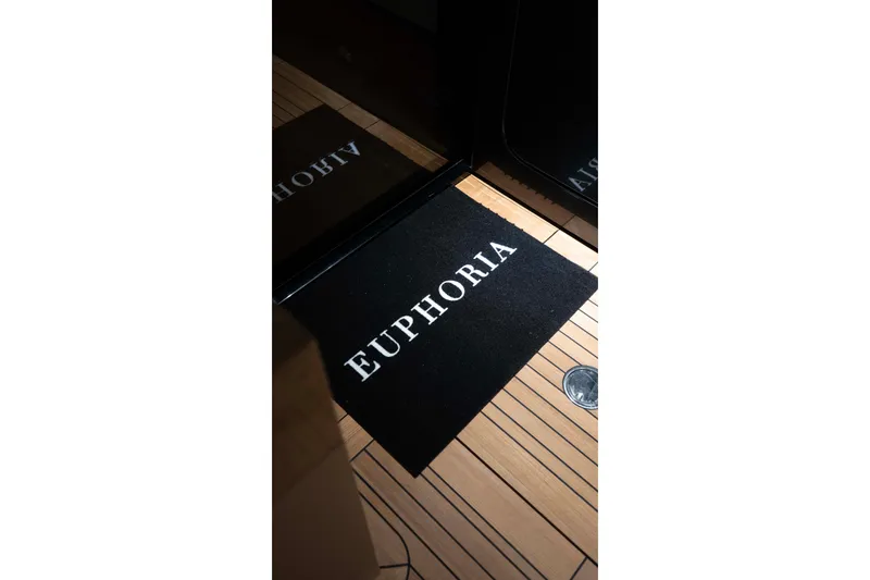 Slide: The Image of Alpha 100 Squalo Co Ownership 2025 yacht with 'Euphoria' welcome mat on deck. - 19