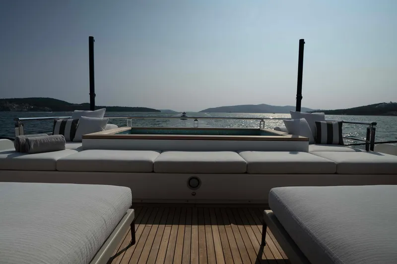 Slide: The Image of Luxurious 2025 Alpha 100 Squalo Co Ownership yacht deck with sun loungers and sea view. - 22