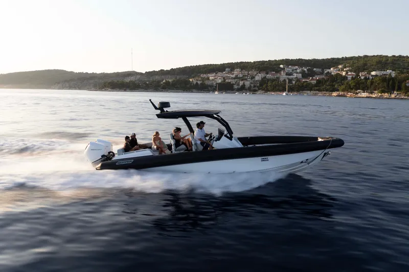 Slide: The Image of 2025 Alpha 100 Squalo Co Ownership boat cruising on serene waters at sunset. - 41