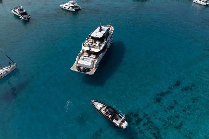 Slide: The Image of Aerial view of luxury yachts, featuring 2025 Alpha 100 Squalo Co Ownership, in clear blue waters. - 6