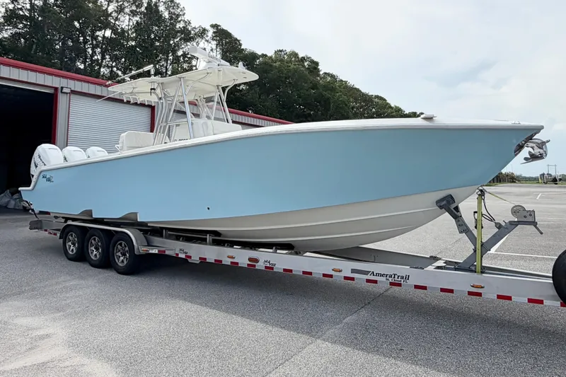 Slide: The Image of 2017 SeaVee 340Z boat on trailer, light blue hull, parked outdoors. - 2