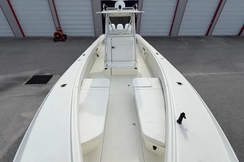 Slide: The Image of 2017 SeaVee 340Z boat with spacious deck and seating, parked near storage units. - 4