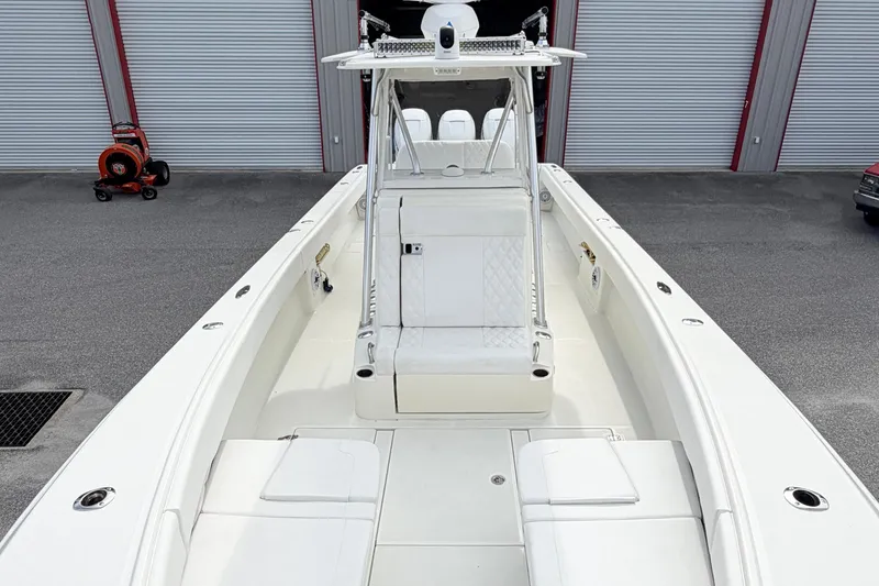 Slide: The Image of 2017 SeaVee 340Z boat with white seating and storage compartments, docked near storage units. - 7