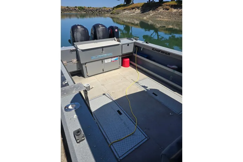 Slide: The Image of 2021 KingFisher 2825 Coastal Express boat interior with dual engines on calm water. - 8