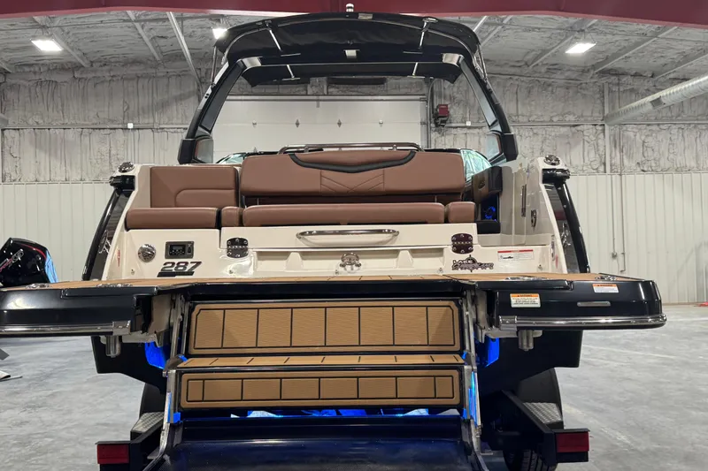 Slide: The Image of 2021 Chaparral 287 SSX boat rear view with seating and swim platform in a garage. - 15