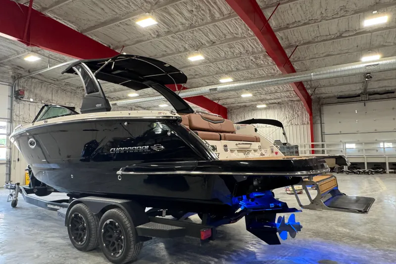 Slide: The Image of 2021 Chaparral 287 SSX boat in a warehouse, black exterior, on a trailer. - 4