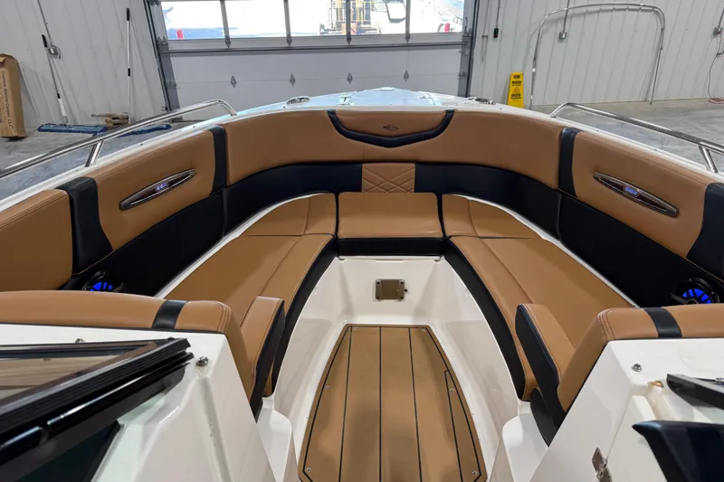 Slide: The Image of 2021 Chaparral 287 SSX boat interior with tan and black seating in a garage. - 6