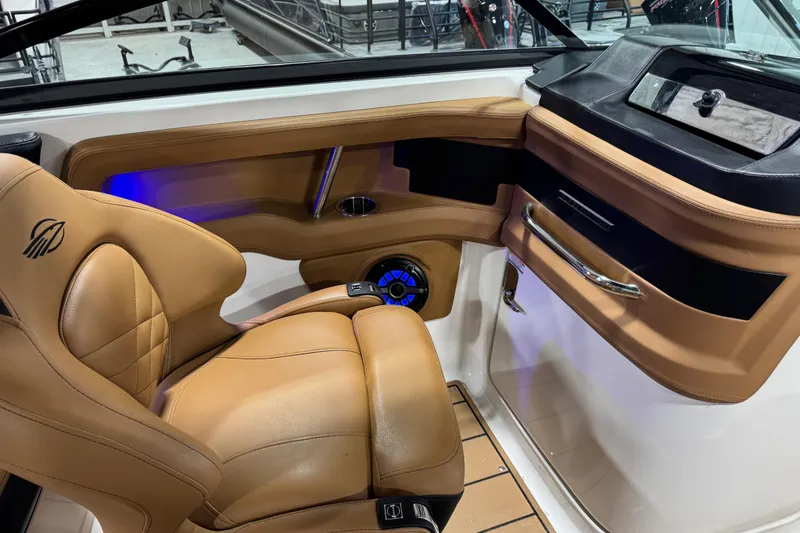 Slide: The Image of 2021 Chaparral 287 SSX boat interior with tan leather seating and modern dashboard design. - 7