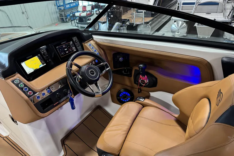Slide: The Image of 2021 Chaparral 287 SSX boat cockpit with modern controls and tan leather seating. - 8