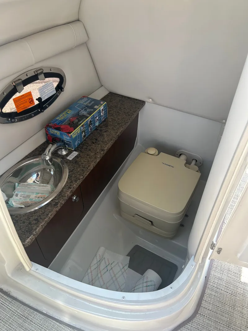 Slide: The Image of Interior of 2019 Crownline E255XS with sink and toilet. - 18