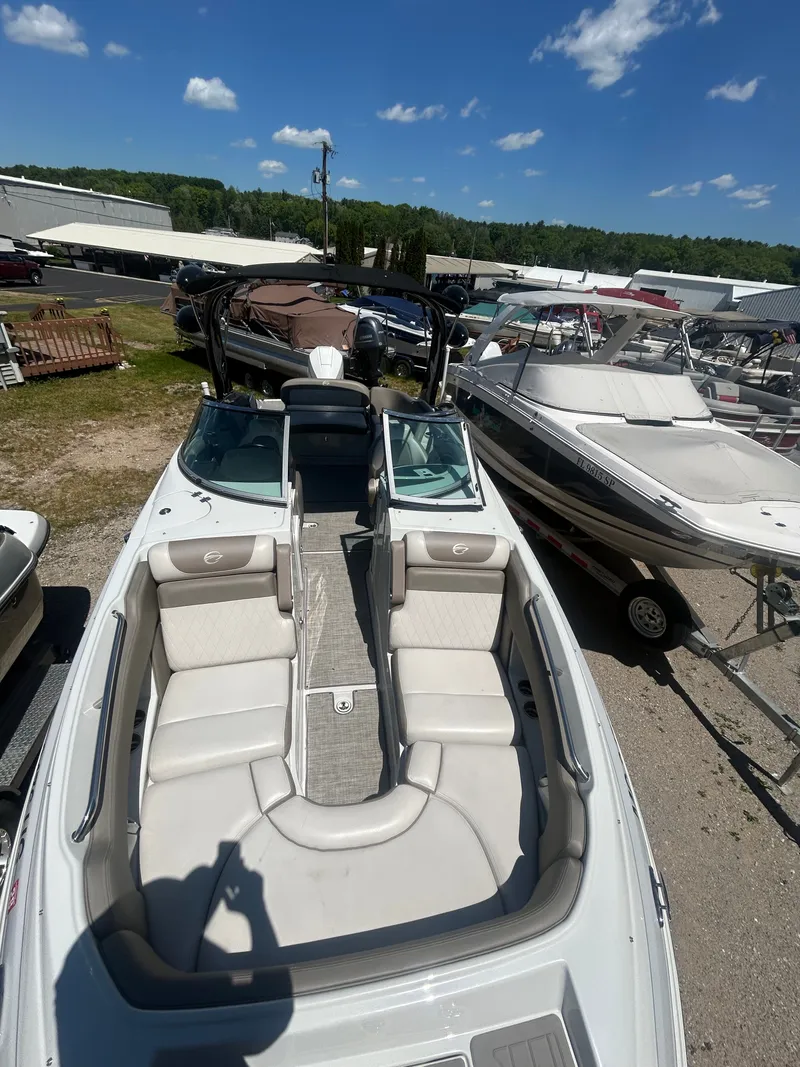Slide: The Image of 2019 Crownline E255XS boat with luxurious interior, parked outdoors. - 20