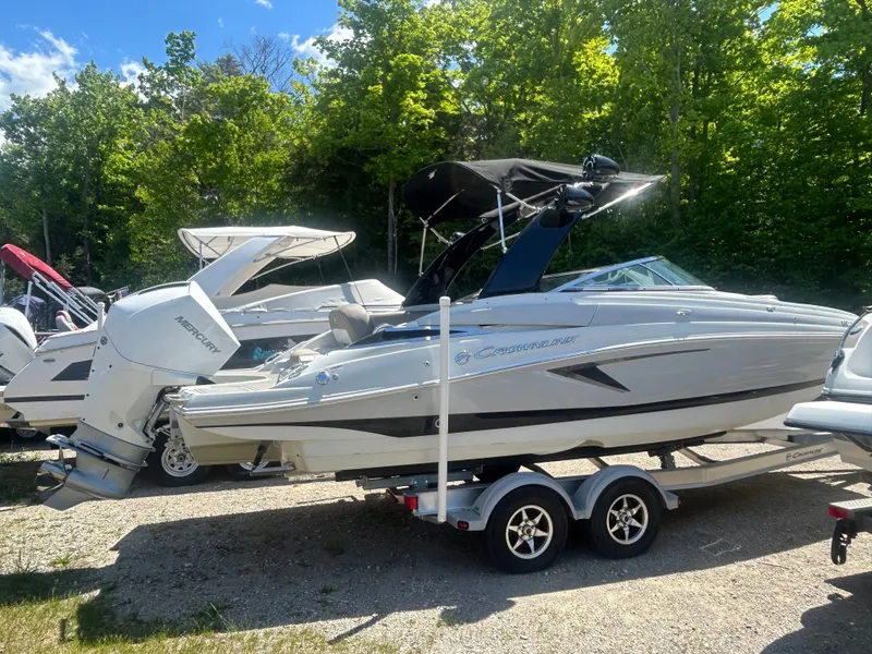 Slide: The Image of 2019 Crownline E255XS boat parked on trailer outdoors. - 4
