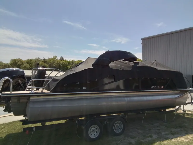 Slide: The Image of 2023 Harris 230 GRAND MARIN pontoon boat with cover on trailer. - 2