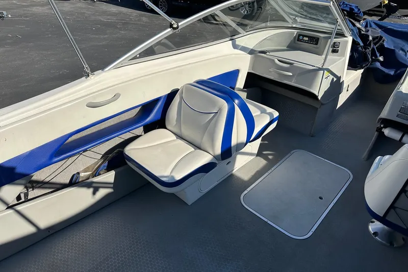 Slide: The Image of 2007 Bayliner Discovery 215 boat interior with blue and white seating and dashboard. - 3