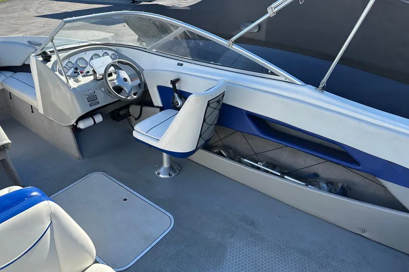 Slide: The Image of 2007 Bayliner Discovery 215 boat interior with steering wheel and seating. - 4
