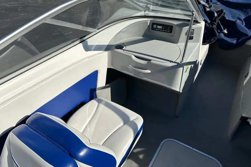 Slide: The Image of Interior of a 2007 Bayliner Discovery 215 boat, featuring blue and white seating. - 5
