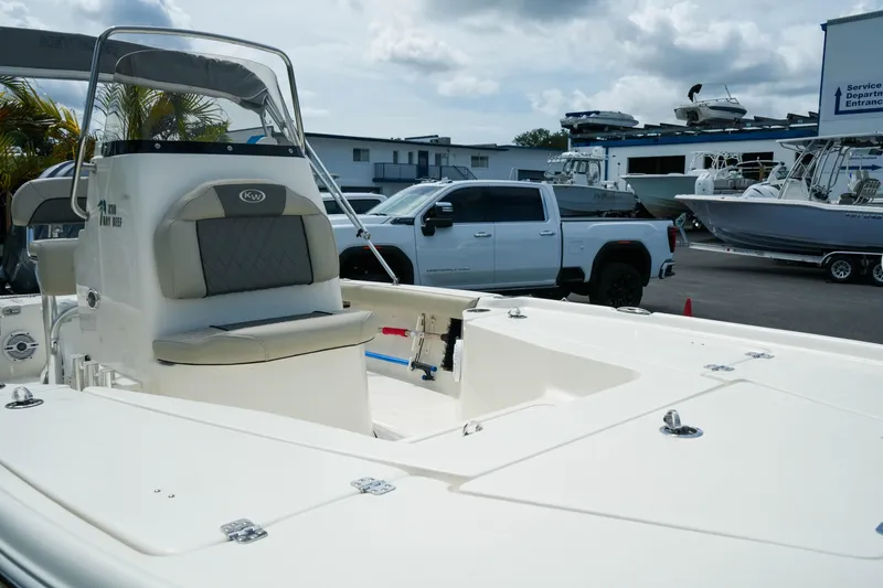 Slide: The Image of 2025 Key West 210 Bay Reef boat displayed at a marina with trucks and boats. - 10