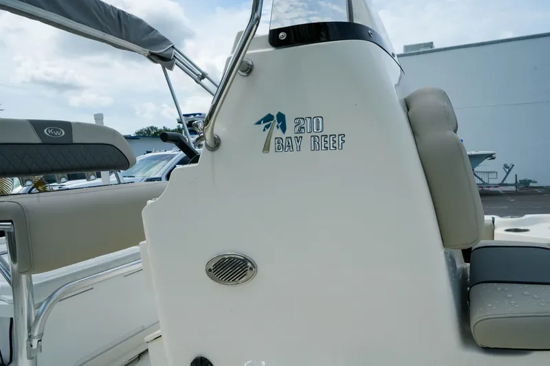 Slide: The Image of 2025 Key West 210 Bay Reef boat interior with seating and logo detail. - 13