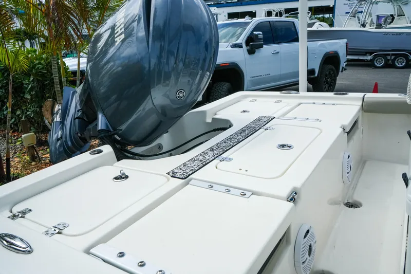 Slide: The Image of 2025 Key West 210 Bay Reef boat with Yamaha engine, parked near a white truck. - 16