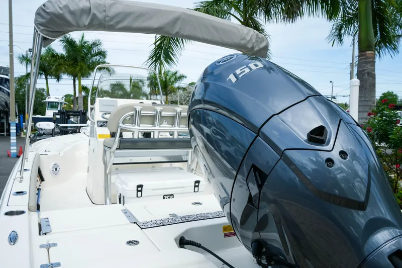 Slide: The Image of 2025 Key West 210 Bay Reef boat with powerful 150 HP engine, docked near palm trees. - 19