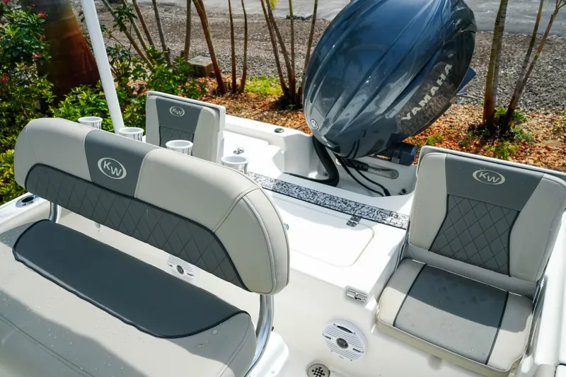 Slide: The Image of 2025 Key West 210 Bay Reef boat interior with Yamaha engine, featuring cushioned seating and cup holders. - 27