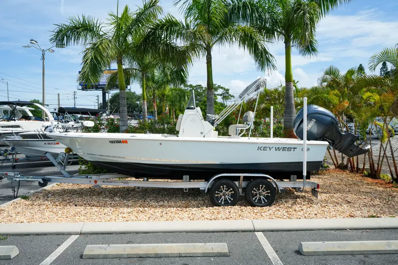 Slide: The Image of 2025 Key West 210 Bay Reef boat on trailer, parked near palm trees. - 3
