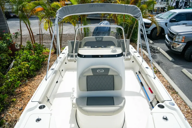 Slide: The Image of 2025 Key West 210 Bay Reef boat with seating and canopy, parked outdoors. - 31