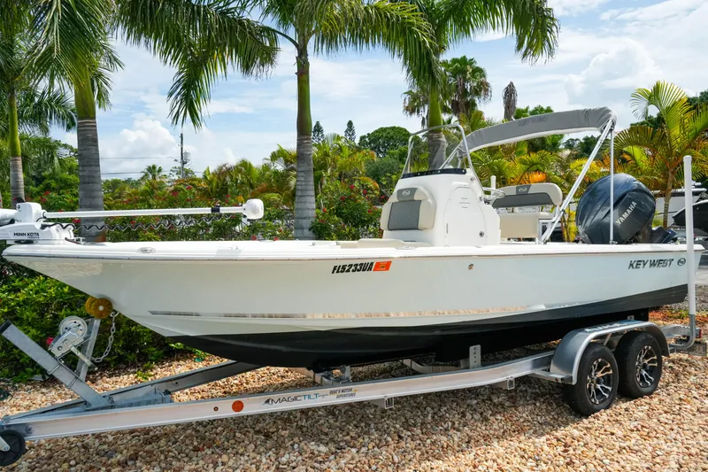 Slide: The Image of 2025 Key West 210 Bay Reef boat on trailer, surrounded by tropical palm trees. - 4