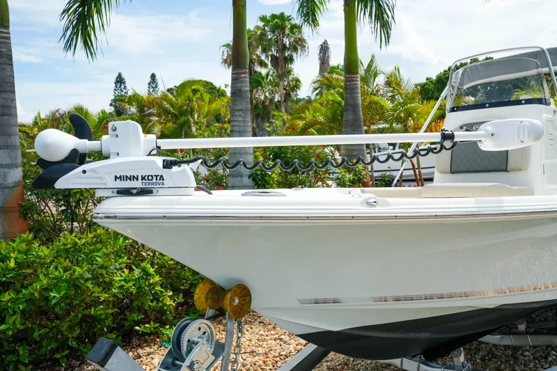 Slide: The Image of 2025 Key West 210 Bay Reef boat with Minn Kota Terrova trolling motor, surrounded by tropical foliage. - 5