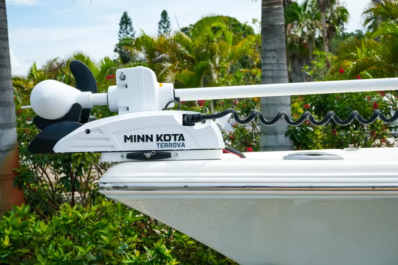 Slide: The Image of 2025 Key West 210 Bay Reef with Minn Kota Terrova trolling motor, surrounded by lush greenery. - 6