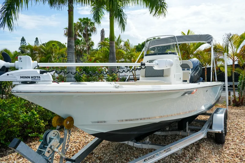 Slide: The Image of 2025 Key West 210 Bay Reef boat on trailer, surrounded by tropical palm trees. - 7