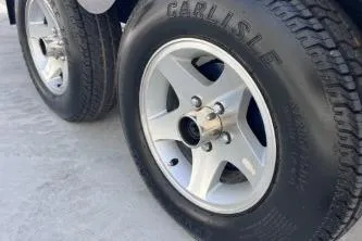 Slide: The Image of 2007 Cobalt 232 trailer wheels with Carlisle tires on concrete surface. - 26