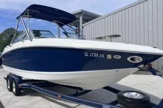 Slide: The Image of 2007 Cobalt 232 boat on trailer, blue and white, parked outdoors. - 4