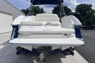 Slide: The Image of 2007 Cobalt 232 boat, rear view, white and blue, parked outdoors. - 6