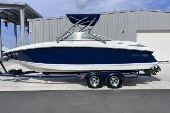 Slide: The Image of 2007 Cobalt 232 boat on trailer, parked near a metal building. - 8