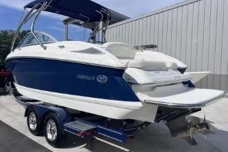 Slide: The Image of 2007 Cobalt 232 boat on trailer, blue and white exterior, parked near a metal building. - 9