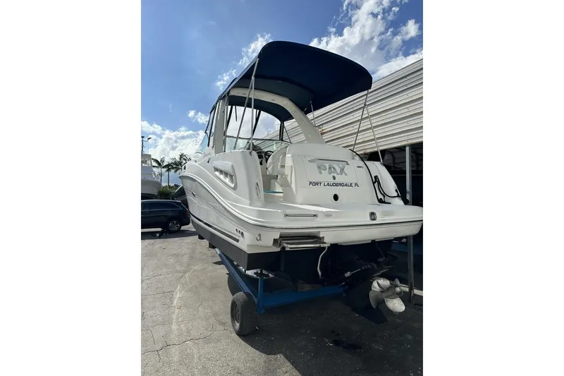Slide: The Image of 2008 Sea Ray Sundancer 260 boat on trailer, Fort Lauderdale, blue canopy, sunny day. - 22