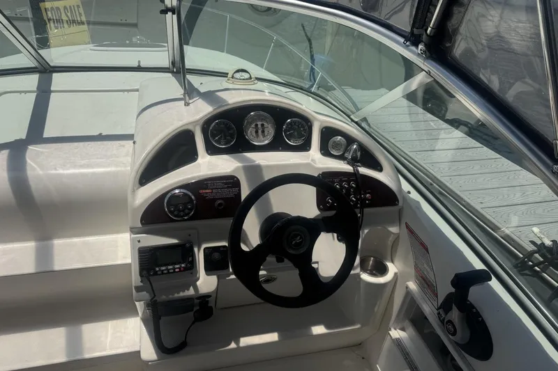 Slide: The Image of 2008 Sea Ray Sundancer 260 helm with steering wheel, gauges, and controls, for sale sign visible. - 26