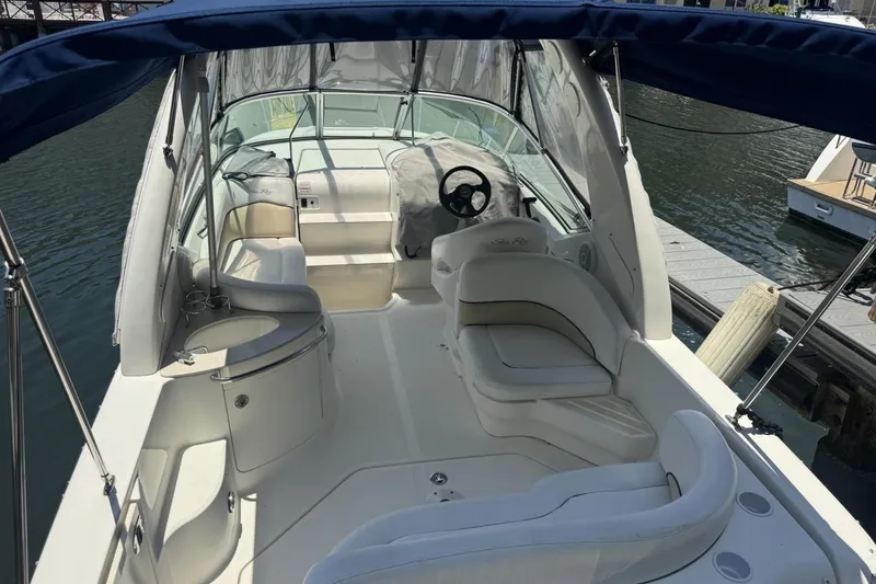 Slide: The Image of 2008 Sea Ray Sundancer 260 boat interior with seating and steering wheel, docked by the water. - 51