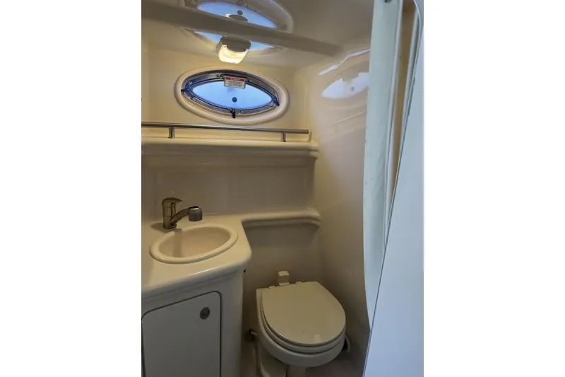 Slide: The Image of 2008 Sea Ray Sundancer 260 bathroom with sink, toilet, and porthole window. - 39