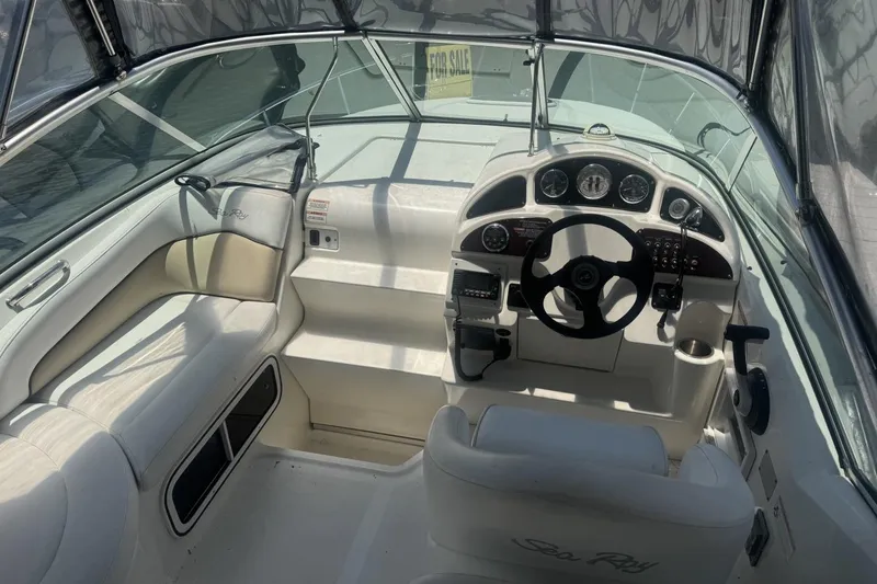 Slide: The Image of 2008 Sea Ray Sundancer 260 cockpit with steering wheel, gauges, and seating, for sale sign visible. - 28