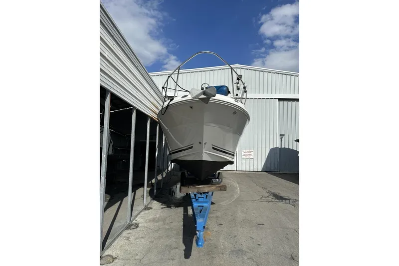 Slide: The Image of 2008 Sea Ray Sundancer 260 boat on a stand outside a metal building. - 24