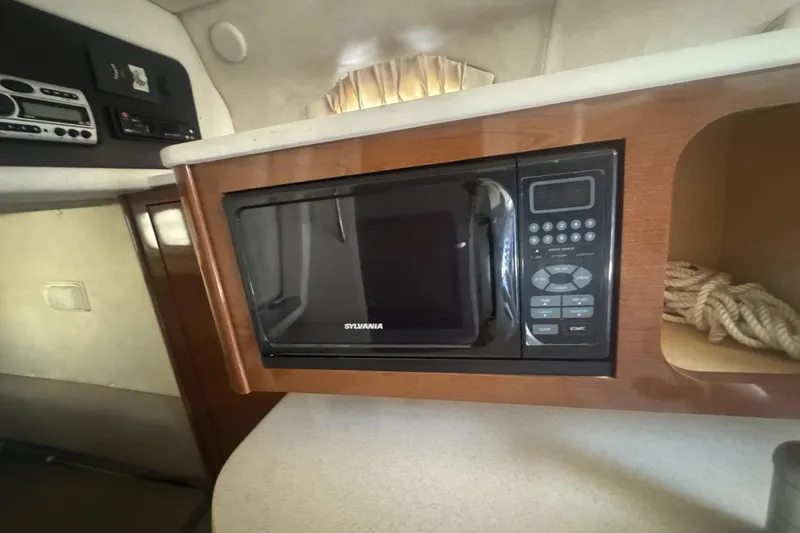 Slide: The Image of Microwave in 2008 Sea Ray Sundancer 260 cabin, featuring wood cabinetry and modern controls. - 35