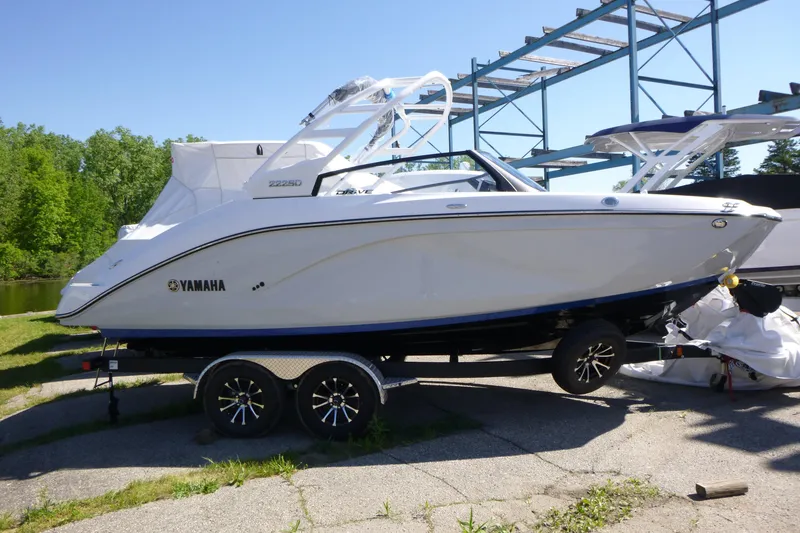 The Image of 2026 Yamaha Boats 222SD on trailer, sleek design, parked outdoors near water. - 1