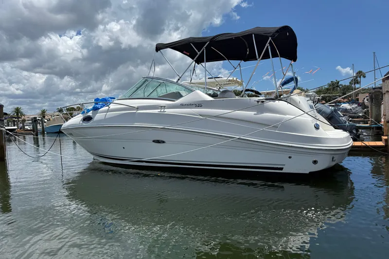 The Image of 2009 Sea Ray 240 Sundancer boat docked under cloudy sky. - 1