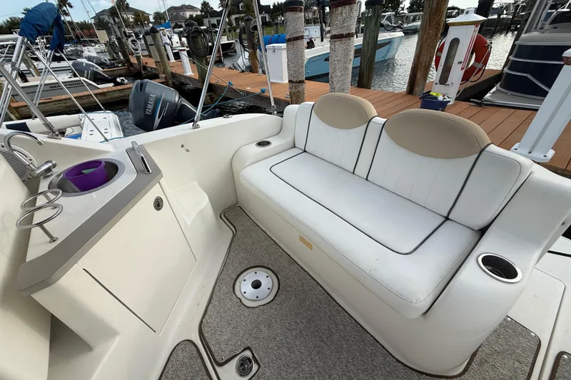 Slide: The Image of 2009 Sea Ray 240 Sundancer boat interior with seating and sink, docked at marina. - 10