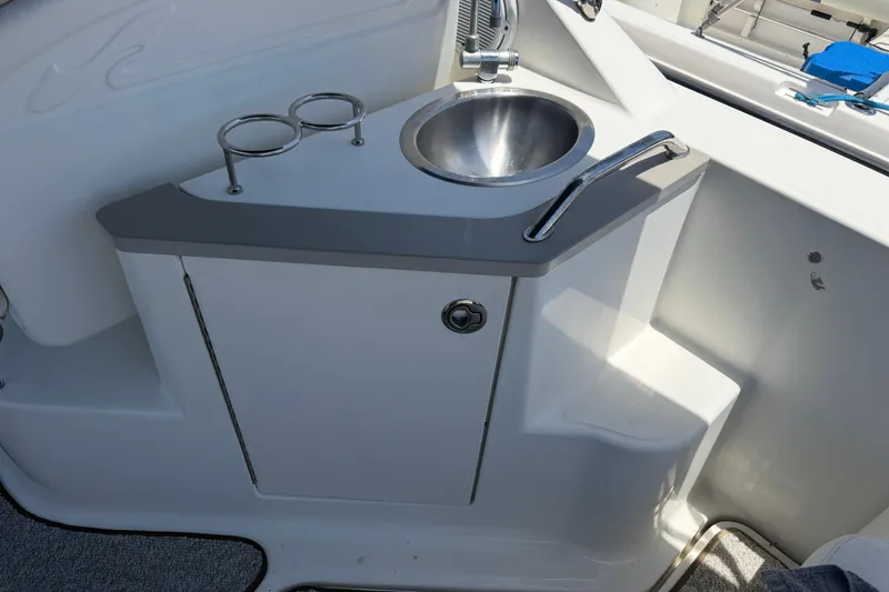 Slide: The Image of 2009 Sea Ray 240 Sundancer boat sink with faucet and cup holders. - 11